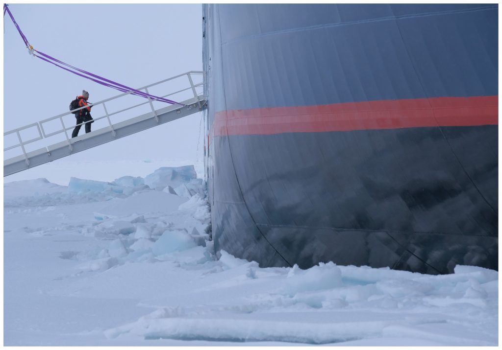 Guest walking up gangway from sea ice to ship. 