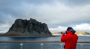 Guest standing on deck of ship photographic Radstock Rock. 