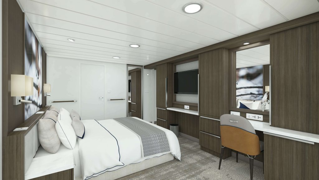 King bed with desk & chair and flat screen TV on the wall.