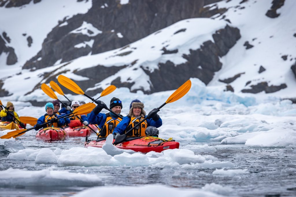 Kayakers paddling in icy waters in Antarctica