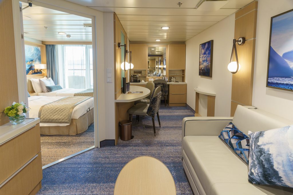 Interior of Junior Suite on Ocean Explorer showing couch, small table and entrance to separate bedroom