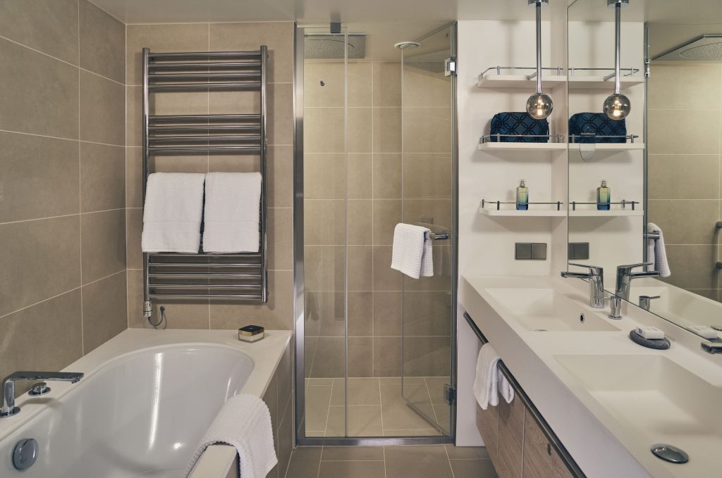 Bathroom with bathtub, walk in shower & 2 sinks on National Geographic Endurance & Resolution.