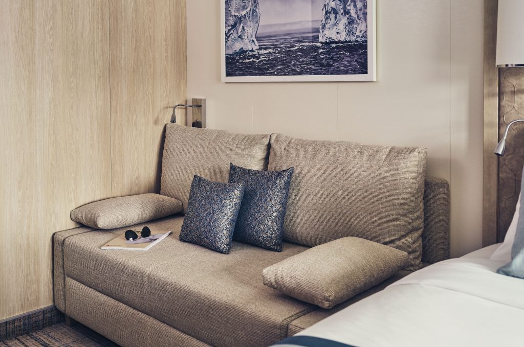 Double couch next to bed in Category 2 cabin on National Geographic Endurance & Resolution.