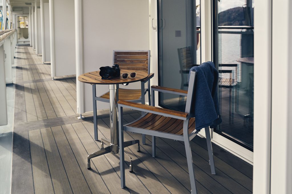 Two wooden chairs and small table on balcony.