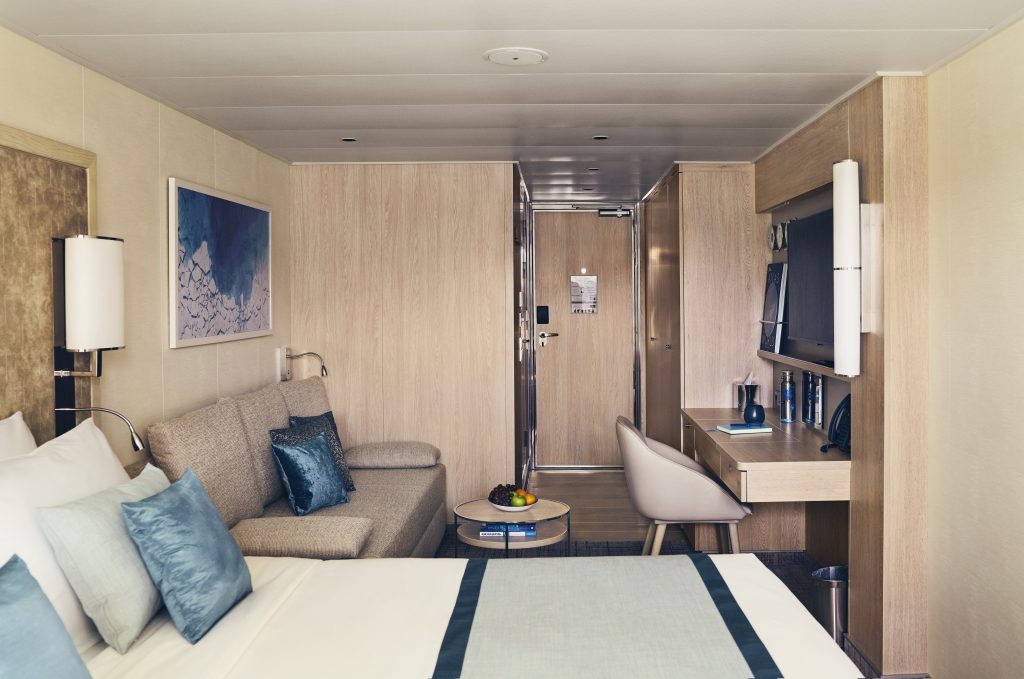 Bed, couch and desk in cabin on National Geographic Endurance & Resolution.