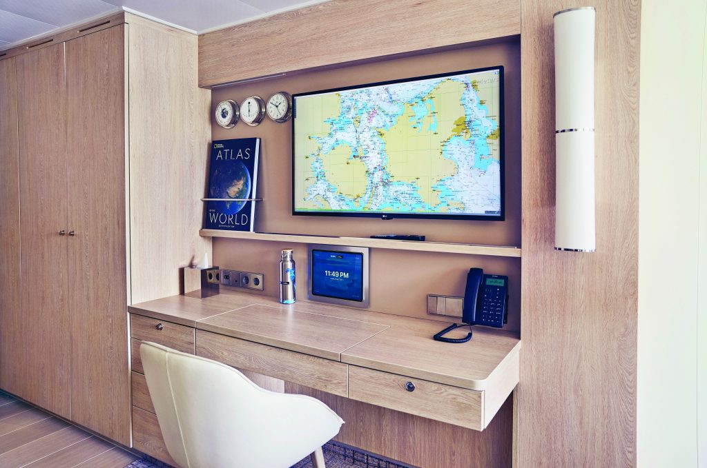 Desk, flat Screen TV on wall and closet.