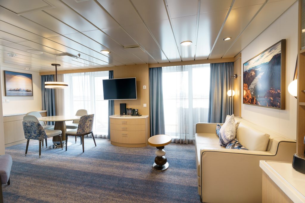 Interior of owner's suite on the ship Ocean Explorer showing couch, circular table with chairs and tv.