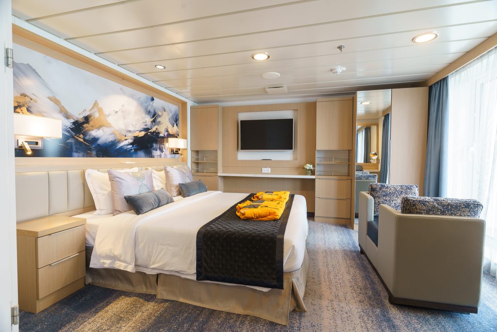 Bedroom of owners's suite on Ocean Explorer with 1 double bed, couch facing window and tv