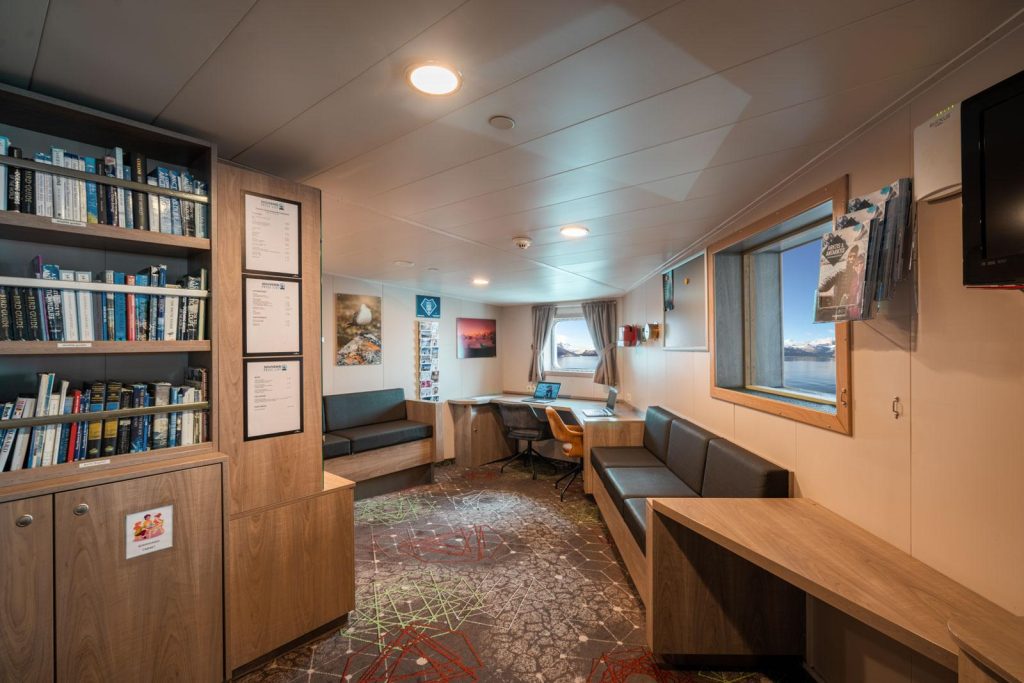 Bookshelf, bench seating and 2 laptops in the library on Plancius.