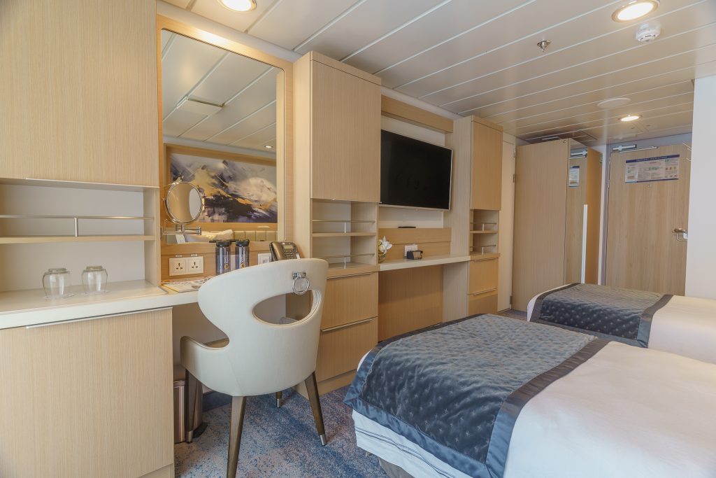 interior of Veranda Stateroom on Ocean Explorer showing desk, chair, TV and 2 twin beds.