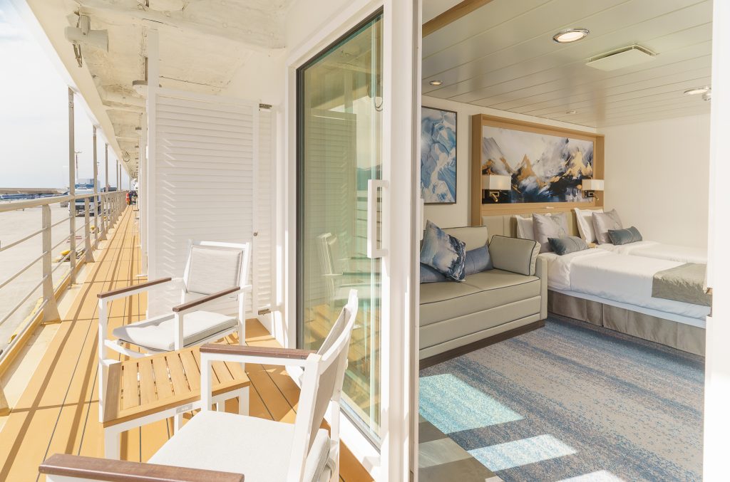 View of balcony with chairs and interior of Veranda Suite on Ocean Explorer