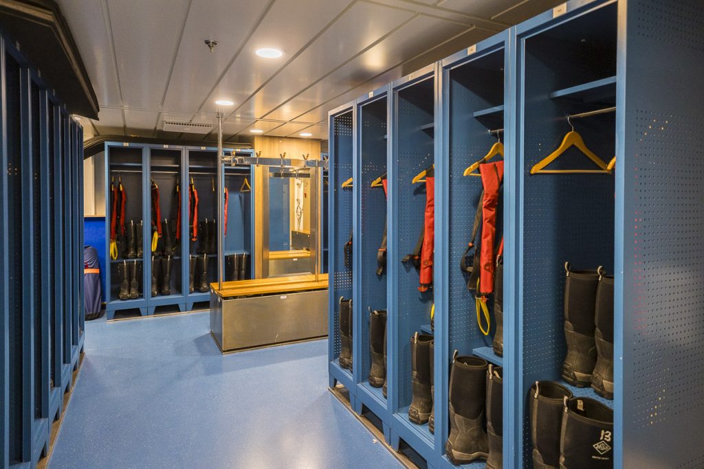 Mudroom on Sylvia Earle showing blue lockers with life jackets and waterproof boots.