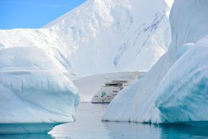 The ship Greg Mortimer between icebergs in Antarctica.