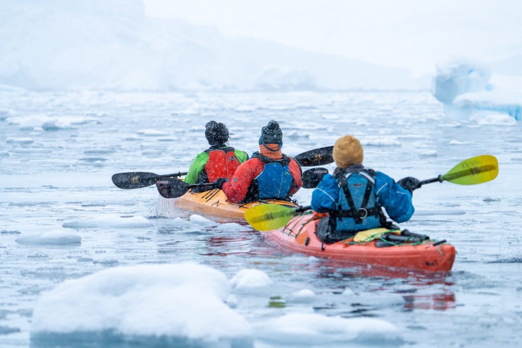 people kayaking in the icy waters of Antarctica.