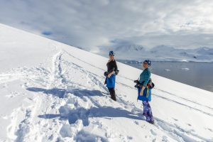 Passengers standing in the snow in Antarctica.
