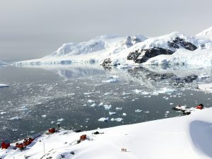 A bay surrounded by snow covered mountains at the Antarctic Peninsula.