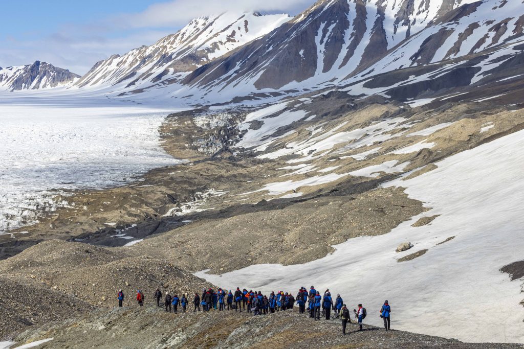 Guest hiking up hillside in Svalbard.