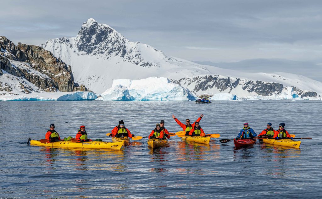 Kayakers on the water with mountain in background.