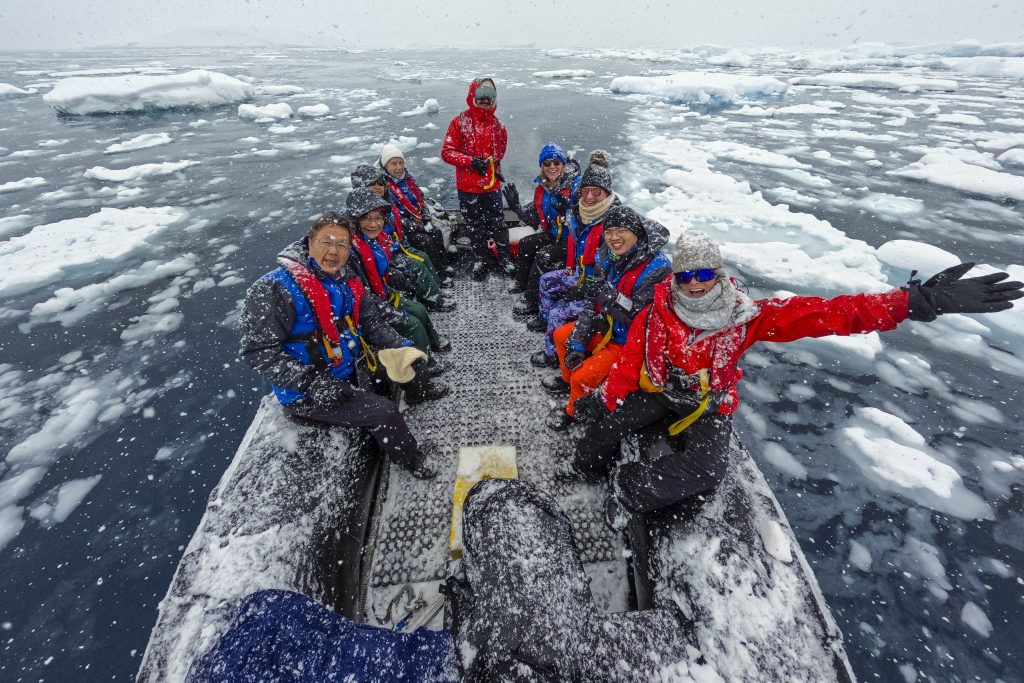 Guests in a zodiac floating in icy water.