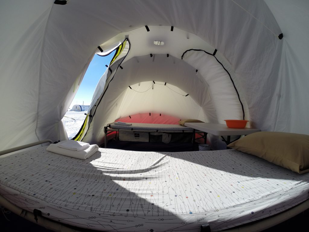 A wide angle view of the interior of a guest's clam tent that accommodates two people.